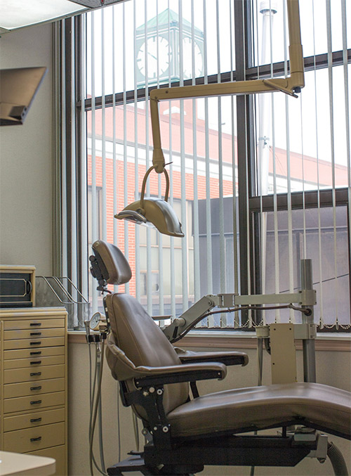 Dentist chair with clock tower seen through window